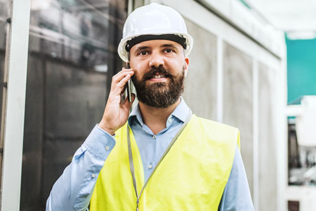 Kontaktaufnahme leichtgemacht Mitarbeiter mit Mobiltelefon am Ohr